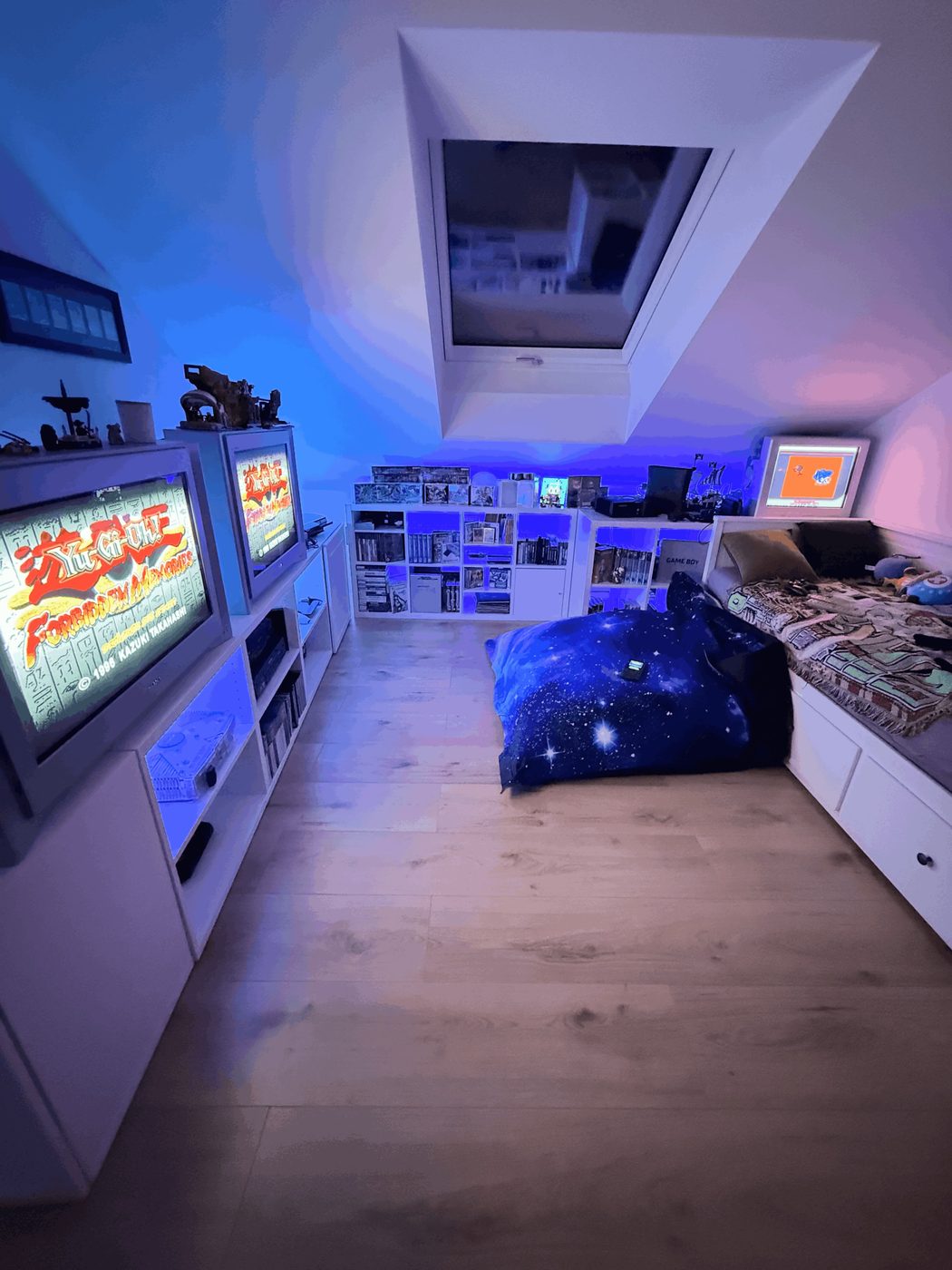 Buri's retro gaming room: CRT TVs running Yu-Gi-Oh Forbidden Memories, shelves of games and a Game Boy bed nook